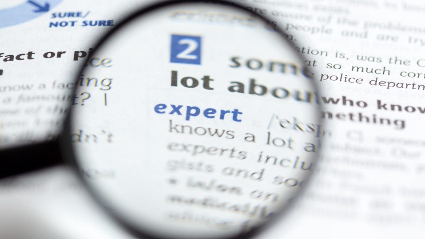 an out of focus magnifying glass focusing on a word in the dictionary